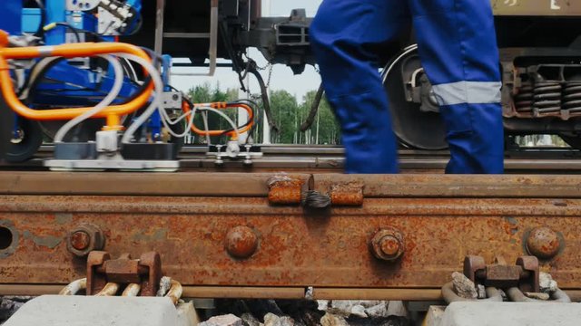 Railroad worker lubricates rails anti-corrosive liquid
