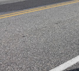 Asphalt road with double yellow and white lines