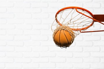 Basketball ball falling into net on sunset