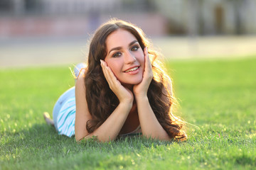 Young woman lying on green grass in the park