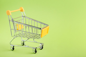 Shopping cart on green background