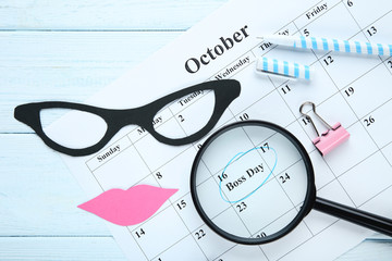 Inscription Boss Day in calendar with magnifying glass and paper glasses