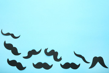 Black paper mustache on blue background
