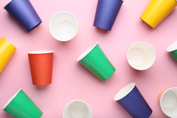 Colorful paper cups on pink background