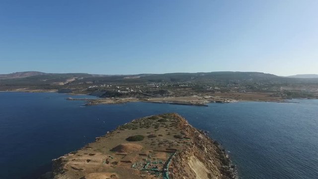 Aerial drone shot over Yeronisos sacred island off the coast of Cyprus as birds fly over the island