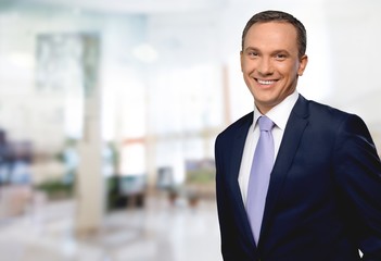 Fototapeta premium Portrait of happy businessman on background
