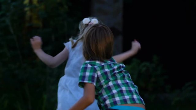 Cheerful kids playing tag game, boy running after girl, childrens outdoor game