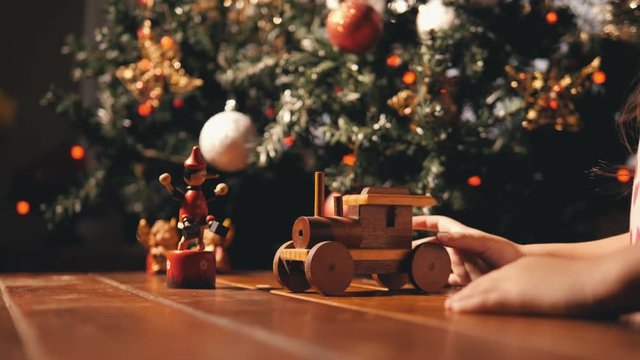 Child playing with wooden train, having fun with christmas decoration