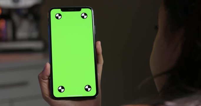 Woman holding green screen smartphone