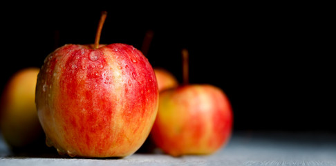 Red apple fruits on white wooden table and black wall background