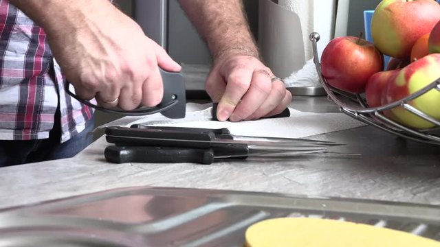The man is sharpening a kitchen knife