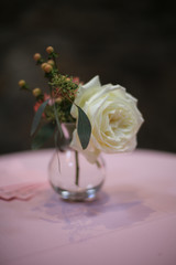 Minimalist Wedding Decor Centerpiece Pink and White Roses in a Glass Vase on a Table with a Pink Tablecloth