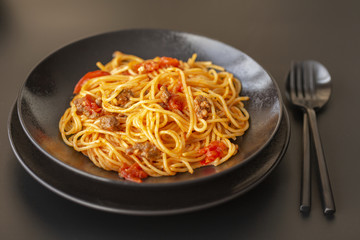 Delicious spaghetti with Bolognese sauce served on a black plate