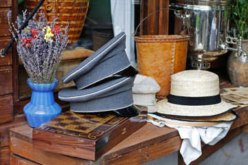 Beautiful bouquet of lavender in vase, peaked caps, hats and chessboard lie on a wooden counter