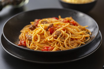 Delicious spaghetti with Bolognese sauce served on a black plate