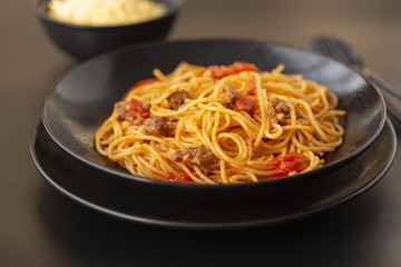 Delicious spaghetti with Bolognese sauce served on a black plate