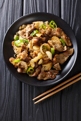 Dak Ddong Jjip - Fried chicken stomachs with onions, garlic, chili and sesame close-up. Vertical top view