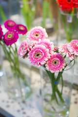 beautiful pink gerbera flowers bouquet in glass vase at display on flower market for sale