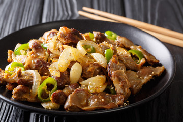 Traditional Korean spicy chicken gizzard with onions, garlic, chili and sesame close-up. horizontal