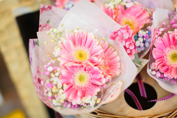 Close up beautiful pink gerbera flowers bouquet in at display on flower market for sale, top view