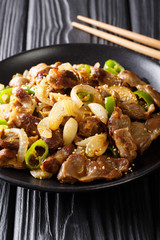 Korean Dak-ttongjip stir-fried chicken gizzard with spices close-up on a table. Vertical