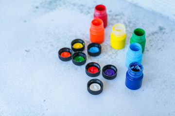 colorful Gouache or acrylic paints in jars on white grunge background, selective focus