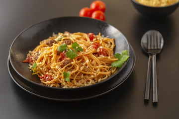Delicious spaghetti with Bolognese sauce served on a black plate