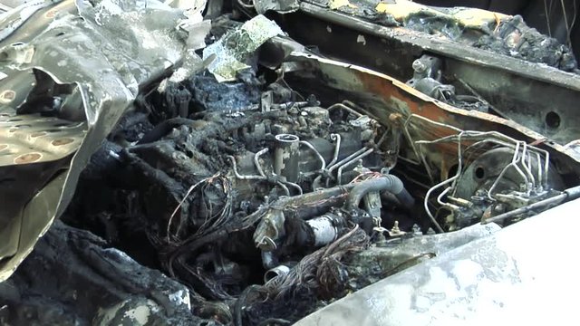 The Car After the Fire. Burnt Out Car With an Open Hood. Engine Burned Out Car Wreck After a Fire. Vandalism.