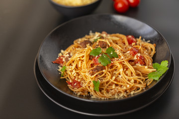 Delicious spaghetti with Bolognese sauce served on a black plate