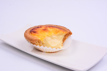 Half eaten cheese tart pastry in a white ceramic plate isolated on white background.
