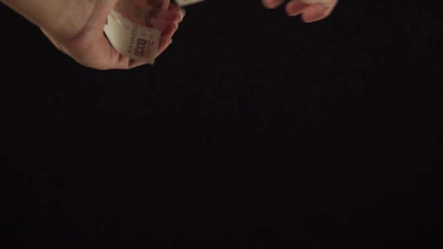 Female hand scatter five thousand rubles banknotes on black background slow motion stock footage video