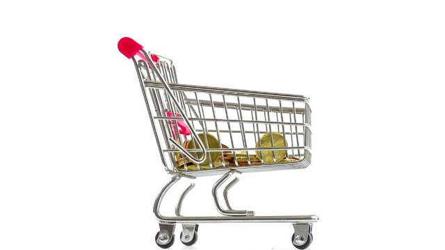 Shopping cart with coins falling , turning. Concept of success in business