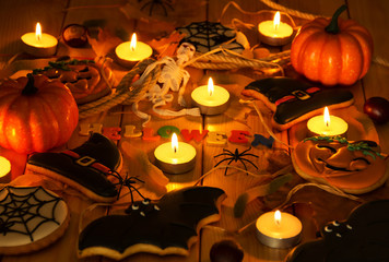 Halloween. Spice-cakes of pumpkin and spiders, burning candles and other festive accessories on boards