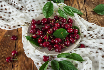 Fresh berries cherries in bowl with water drops on a white napkin