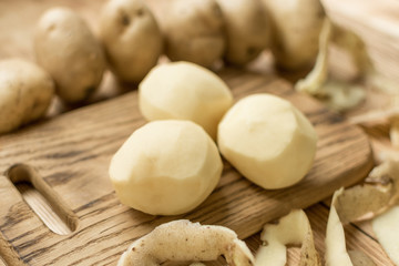 Fototapeta na wymiar Raw tubers peeled potatoes on a wooden background.