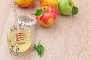 Jewish holiday Rosh Hashanah background with honey and apples on wooden table.