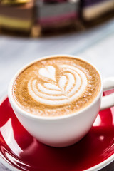 A cup of art coffee cappiciino and mini raw cakes