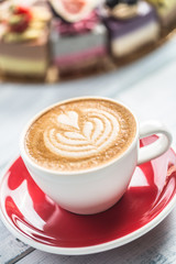 A cup of art coffee cappiciino and mini raw cakes
