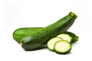 Fresh whole and sliced zucchini isolated on white background. From top view. Courgette zucchini cut...