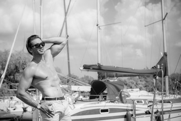 Sexy bearded man standing on the yacht club. Guy on a sailing boat. Handsome man enjoying life,...