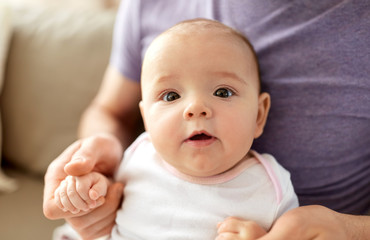 family, parenthood and people concept - close up of father with little baby girl at home