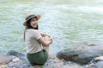 teen girl sitting  near waterfall