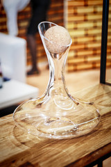 Original empty glass decanter on wooden rack