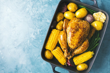 Chicken in baked form with vegetables on table