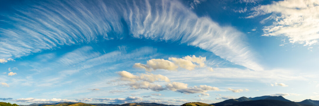 panorama of a gorgeous cloudscape. dynamic high cloud formations on a windy autumn day in mountains