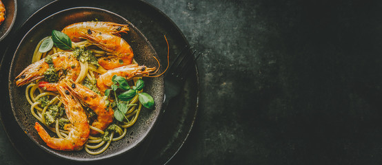 Spaghetti with pesto and prawns served on plate