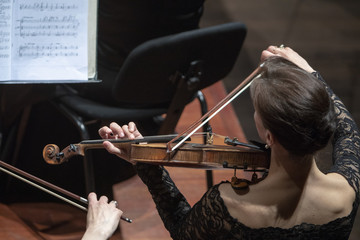 A female violinist during an classical orchestra concert