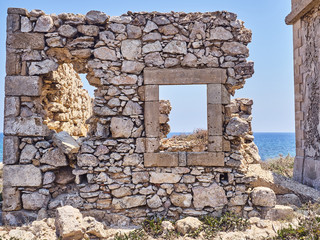 Window on the sea. Shot of the Isola delle Correnti, an island near Portopalo, Sicily.  It is now abandoned han it has ruins of building of the Second World War