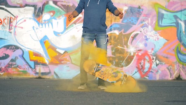 Yong teenager drops a skateboard on a road, slow motion.