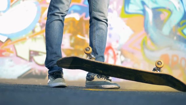 Skateboard falls on a ground, close up.